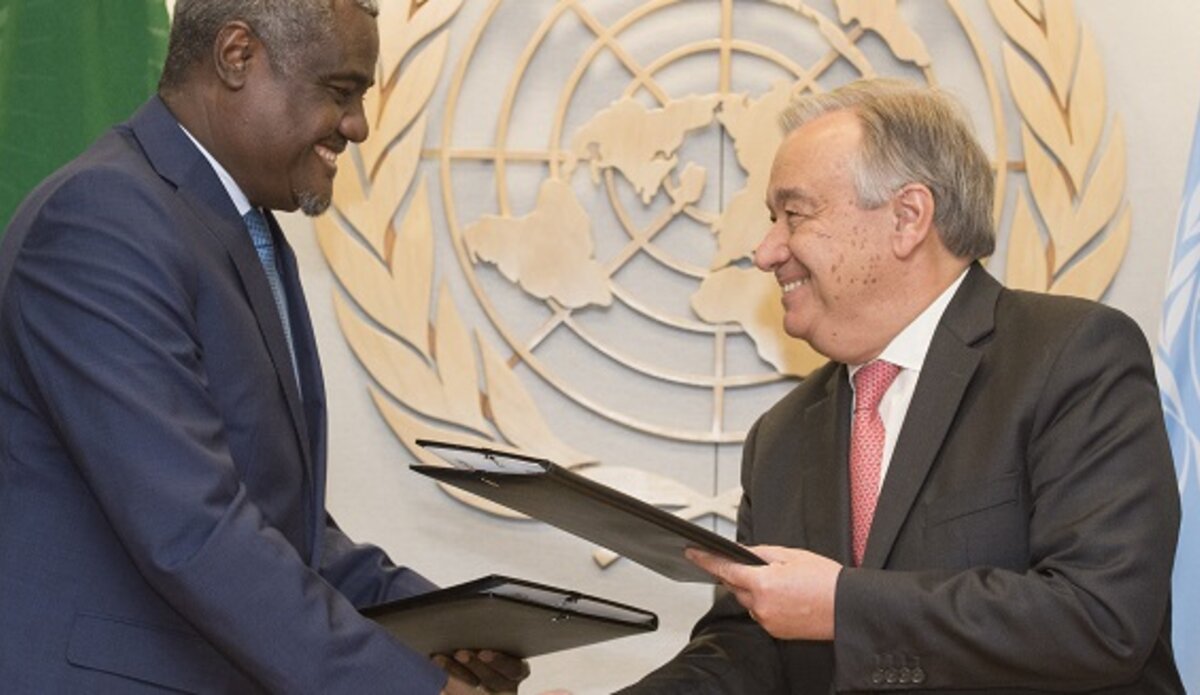 Secretary General António Guterres (right) and Moussa Faki Mahamat, Chairperson of the African Union Commission, shake hands after signing Joint UN-AU Framework for Enhancing Partnerships on Peace and Security.